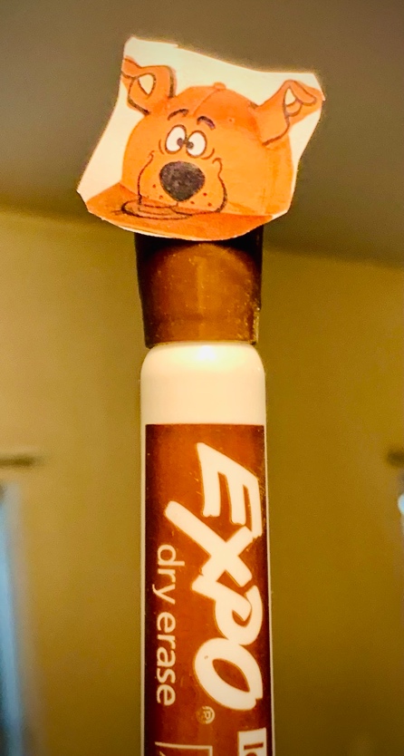 A bottle with a paper hat on top

Description automatically generated